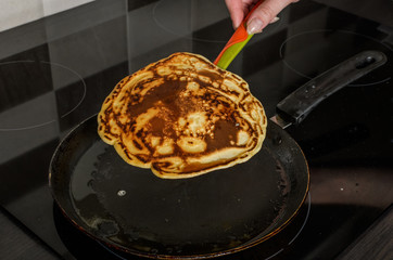 Pancakes are fried in a pan on an induction stove	