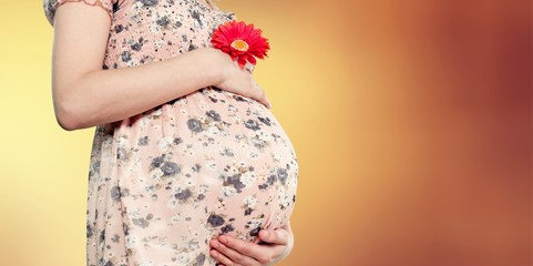 Pregnant woman in dress with red flower