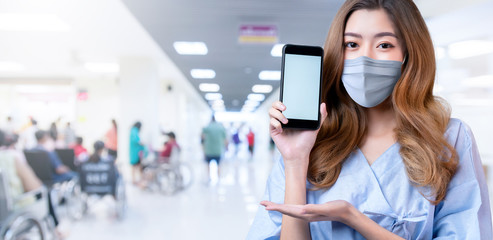 sick patient asian female wear  surgical mask and clinic uniform hand show smartphone blank screen with freshness and cheerful business insurance ideas concept with hospital blur backgound