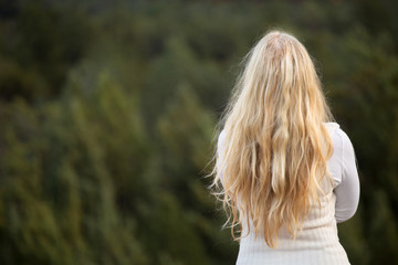 Rear view of a blonde woman smiling.