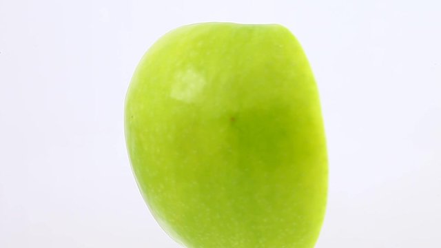 Apple half core one vertically rotate, side view, spinning slowly in a circle, close up.