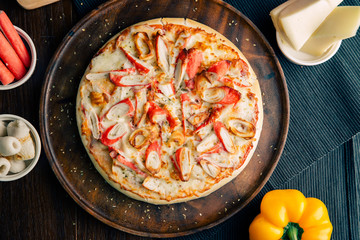 Crab Pizza and Chiku Bologna on a brown wooden plate