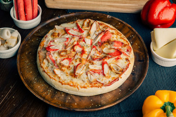  Crab Pizza and Chiku Bologna on a brown wooden plate
