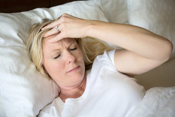 Fototapeta premium Woman having a headache and trouble sleeping.