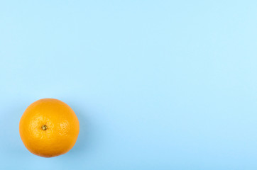Ripe and fresh orange fruit on blue background.