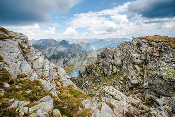 Beautiful mountain scenery - A small mountain lake and rocky mountains. Beautiful landscapes. Rila mountain, Bulgaria. Trekking / hiking concept.