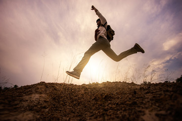 Hiker jumping cheerful expressive successful climbing the mountain. Asian hikers adventure to overcome the limits of life climbing mountain under sunrise.