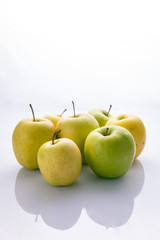 Ripe, green apples on a white background. Farm fruits
