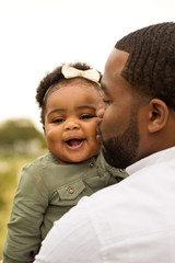 African American father holding his daughter.