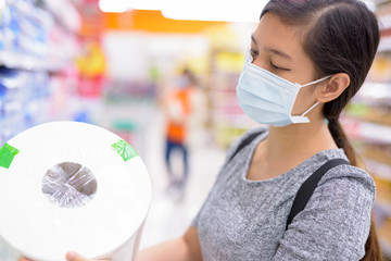 Young Asian woman with mask buying tissue paper at the supermarket
