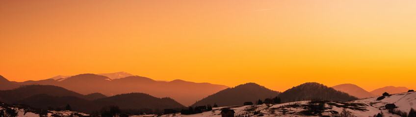 sunset on snowy mountains at the end of winter