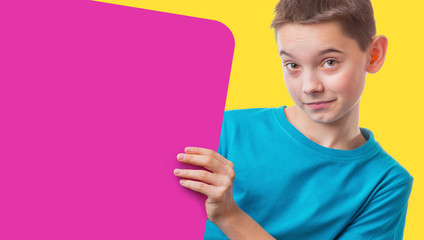 Boy holding empty square pink a sign, on yellow background