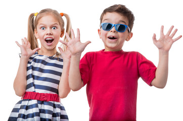 Studio portrait of cheerful little girl and boy in sunglasses raised her palms up, isolated on white background