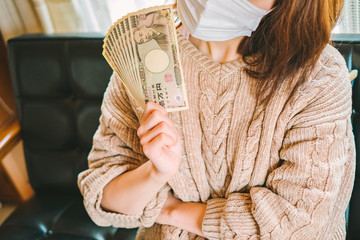 現金10万円を持つ女性　特別定額給付金　家計　へそくり　