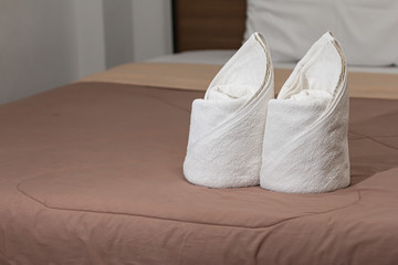 Fototapeta na wymiar White towels set on the bed in the hotel room.