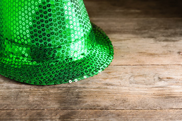 Green leprechaun hat on wooden table, space for text. St. Patrick's Day celebration