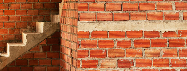 red brick wall and cement ladder in under construction building architecture web banner background