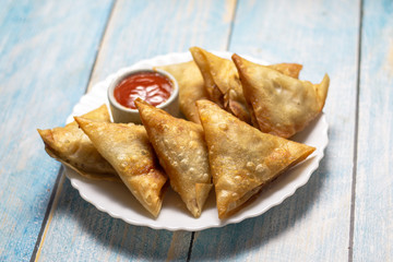 Asian food. Samsa (samosas) with chicken fillet and cheese on wooden background
