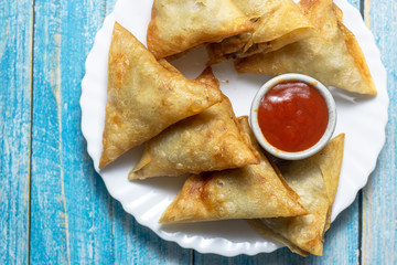 Asian food. Samsa (samosas) with chicken fillet and cheese on wooden background
