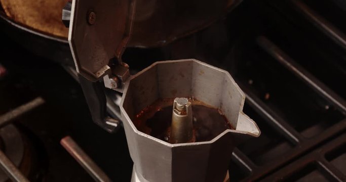 percolator moka pot bubbling and brewing coffee on a gas stove top