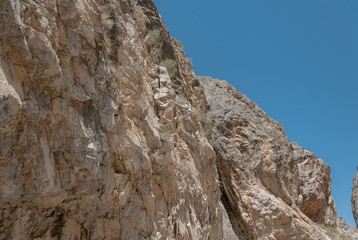 mountains of Central Asia. a narrow road between mountains. rapid river and sparse vegetation. there are no people.