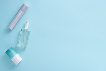 top view three cosmetic bottles on blue background, flat lay, copy space, different packaging