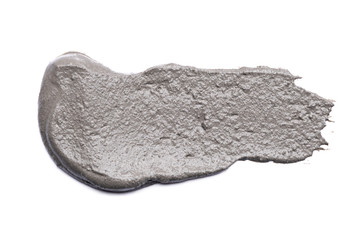 smear of grey cosmetic clay on white background with copy space, wellness concept