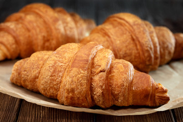 set of fresh baked croissants on wooden table