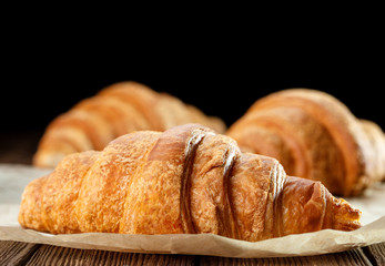 set of fresh baked croissants on wooden table
