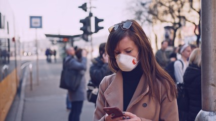Coronavirus disease - woman wearing face mask in public to protect herself from the covid-19 virus.