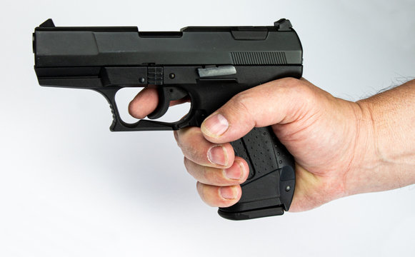 Threatened gun holding before a white wall