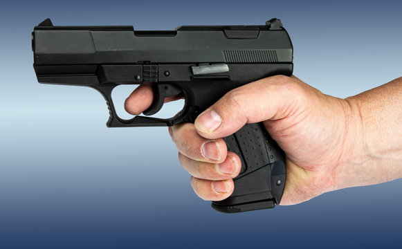 Threatened gun holding before an abstract background