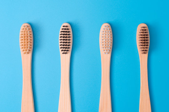 Bamboo toothbrushes on blue background. Eco friendly daily oral hygiene, teeth care and health. Cleaning products for mouth. Dental care concept. Empty place for text or logo.