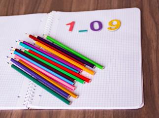 Colored pencils on a graph notebook, top view, back to school and beginning of school year concept
