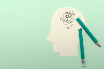Top view of papaer shape of head, broken pencil on the green surface.Empty space.Concept of...
