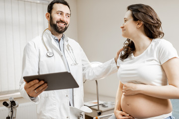 Obraz premium Doctor with pregnant woman during a medical consultation in gynecological office. Concept of medical care and health during a pregnancy