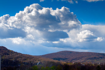 Clouds landscape over the city with blue sky and spring mountains