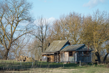 An old wooden bath house on the outskirts of the village. Against the background of the cloudy sky. Concept: old buildings, country style, vintage and antiques