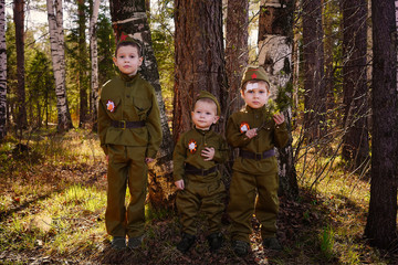 Three boys in uniform in the forest