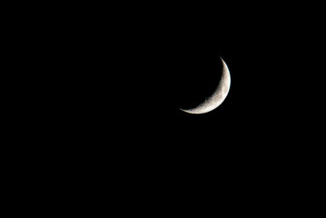 Fototapeta na wymiar young moon on black background - Waxing Crescent
