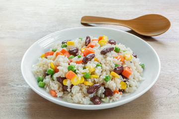 close up of fried rice with vegetable in a ceramic dish on wooden table. homemade style food concept.