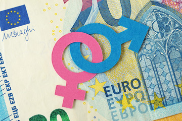 Male and female gender symbols chained together on euro banknote - Gender relations concept