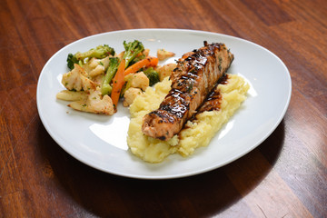 fish served with mashed potatoes and vegetable stew on a serving plate