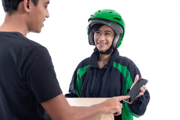 man signing to package he received from delivery courier