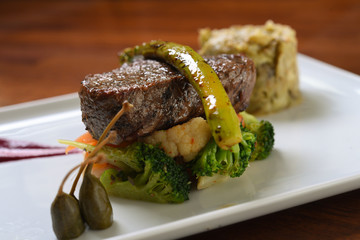 slices of meat and green pepper on vegetables