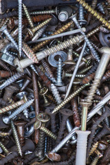 background of old nails, rusty screws and other fasteners