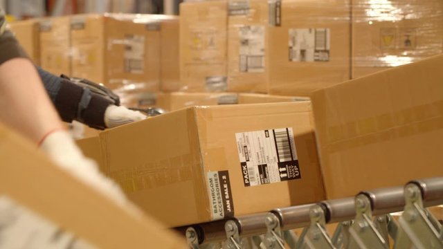 Worker takes Package from a Roller Conveyor / Factory, Warehouse