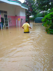 A Man walks in a massive flood caused by high rainfall in the Tangerang area, Indonesia.