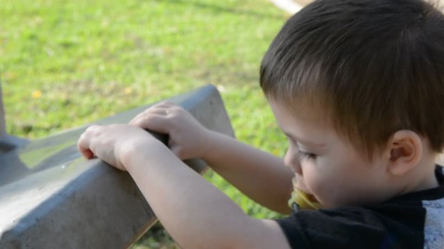 child plays with a water dispenser in the park