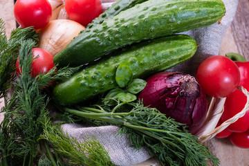 Fresh vegetables vegetables tomatoes, onions, cabbage, bell peppers, cucumbers on a textural wooden background. Close-up.